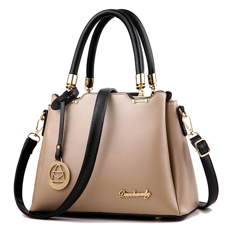 Beige handbag with black handles and strap on a white background