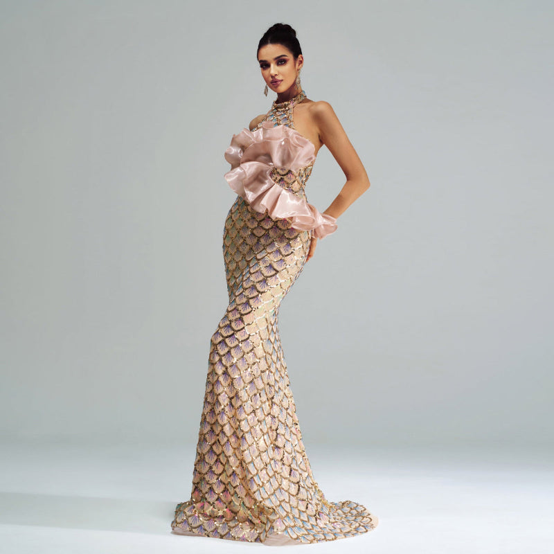 Woman wearing a glamorous evening gown with a large bow on a plain background