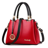 Red handbag with black handles and strap on a white background