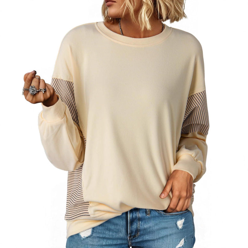 Beige sweater with striped sleeves worn by a person on a white background