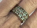 Gold ring with floral design on a finger