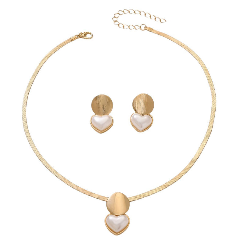 Gold necklace and earrings with heart-shaped designs on a white background