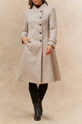 Woman wearing a beige coat on a beige background