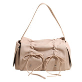 Beige handbag with bow details on a white background