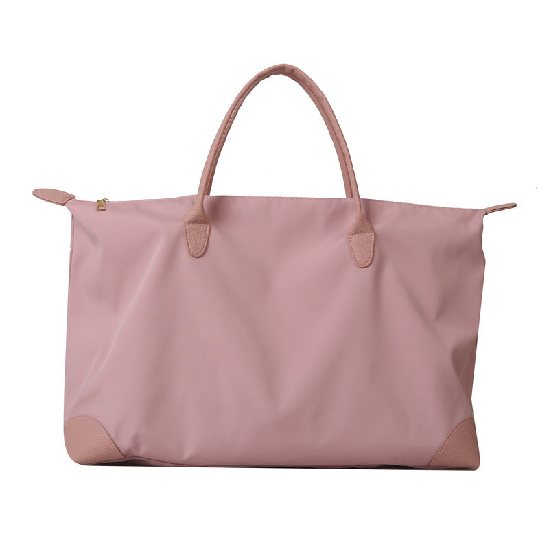 Pink tote bag with leather handles and corners on a white background