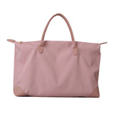 Pink tote bag with leather handles and corners on a white background