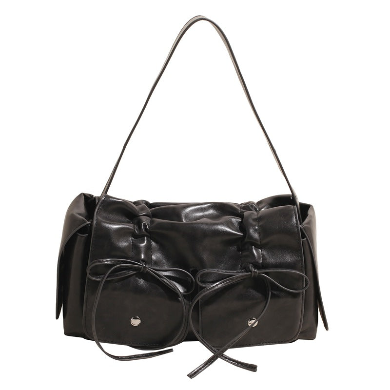 Black handbag with bow details on a white background