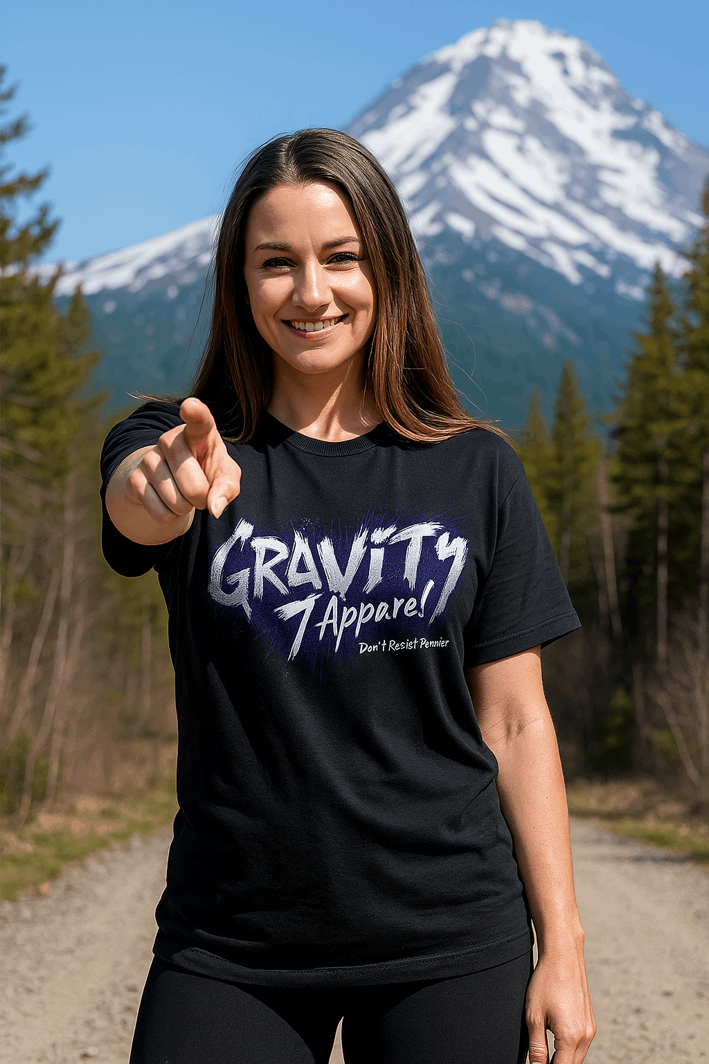 Woman wearing a black t-shirt with 'Gravity Apparel' logo in a mountainous landscape