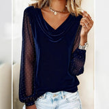 Navy blue long-sleeve top with sheer sleeves worn by a person, with a neutral background.