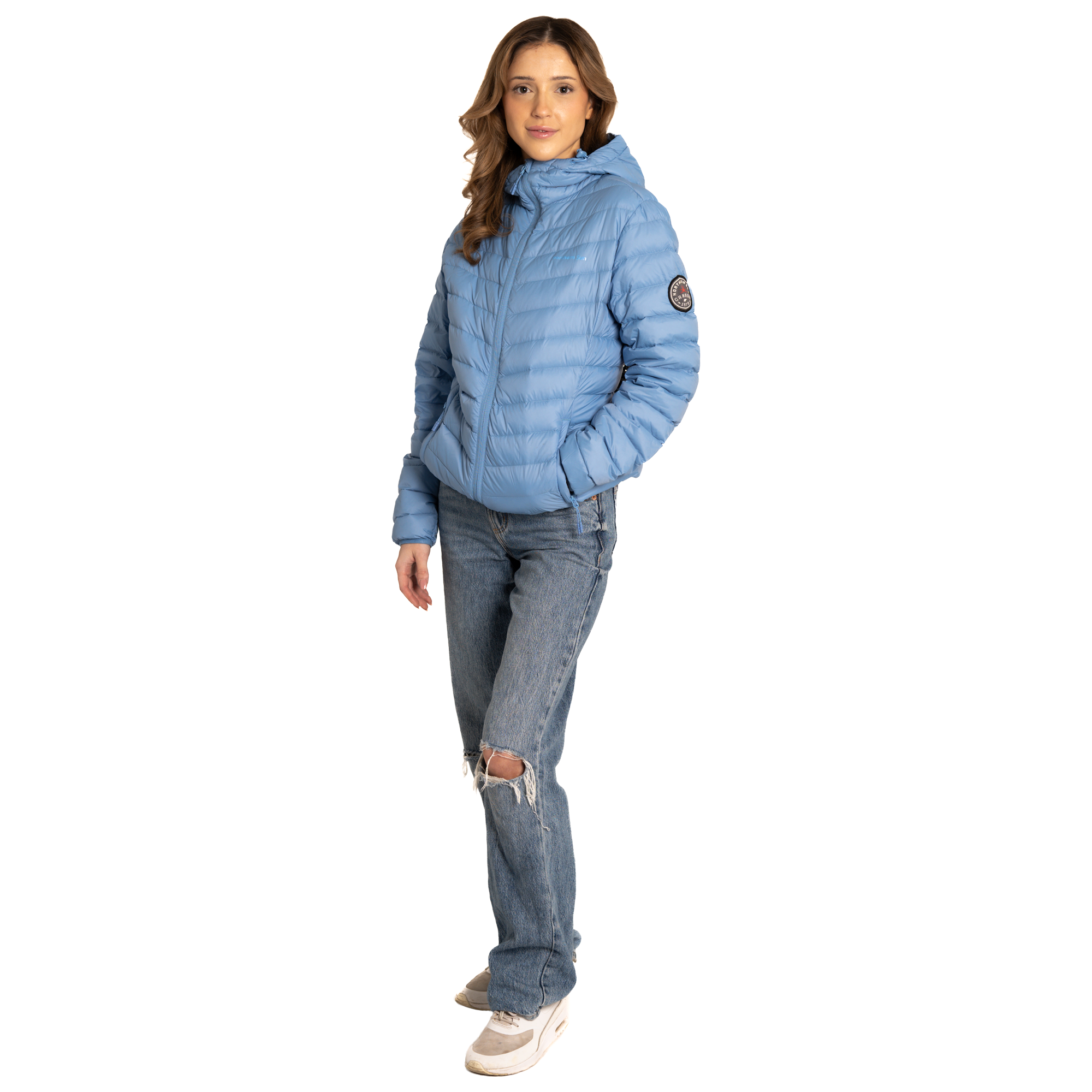 Woman wearing a blue puffer jacket and jeans on a white background