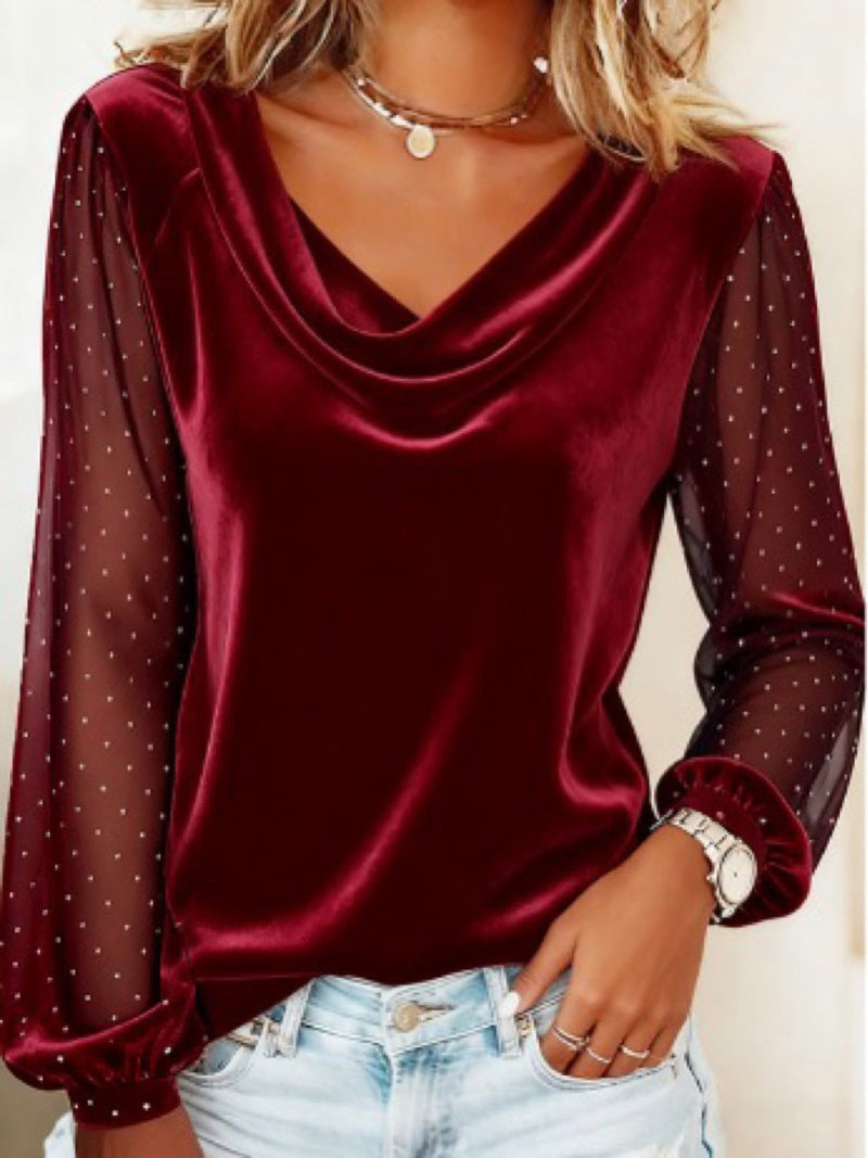 Red satin blouse with sheer sleeves worn by a person against a neutral background