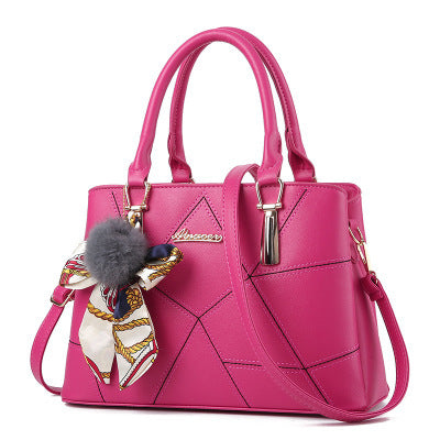 Pink handbag with a decorative charm on a white background