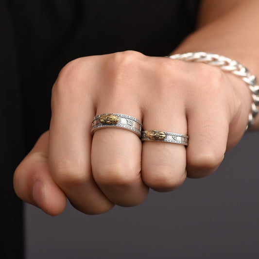 Close-up of a hand wearing two silver rings with a dark background