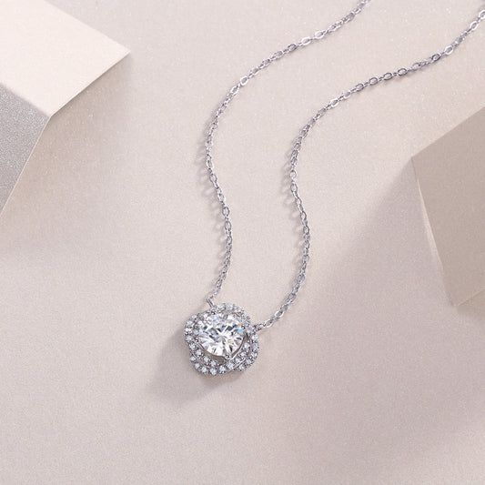 Silver necklace with a sparkling pendant on a light beige background