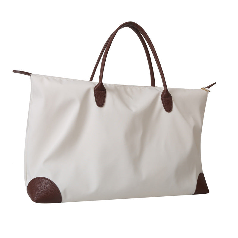 White tote bag with brown handles and accents on a white background