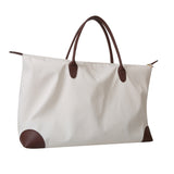 White tote bag with brown handles and accents on a white background